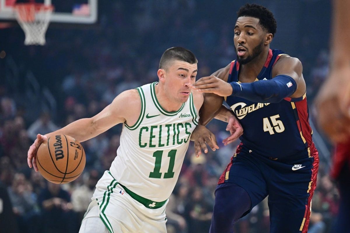 Nov 30, 2025; Cleveland, Ohio, USA; Boston Celtics guard Payton Pritchard (11) drives on Cleveland Cavaliers guard Donovan Mitchell (45) during the first half at Rocket Arena. Mandatory Credit: David Dermer-Imagn Images