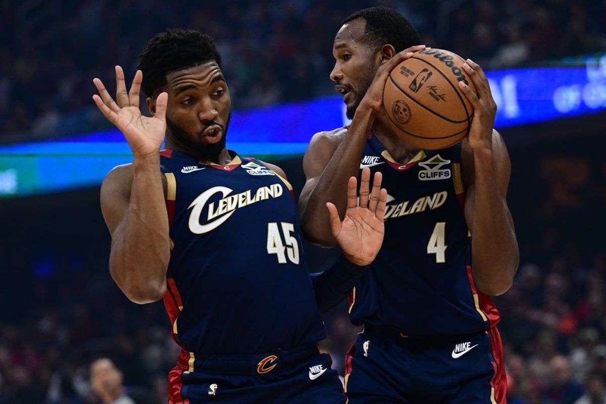 Nov 30, 2025; Cleveland, Ohio, USA; Cleveland Cavaliers guard Donovan Mitchell (45) gets out of the way as center Evan Mobley (4) grabs a rebound during the first half at Rocket Arena. Mandatory Credit: David Dermer-Imagn Images