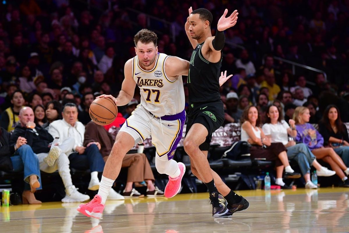 Nov 30, 2025; Los Angeles, California, USA; Los Angeles Lakers guard Luka Doncic (77) moves the ball against New Orleans Pelicans guard Bryce McGowens (11) during the first half at Crypto.com Arena. Mandatory Credit: Gary A. Vasquez-Imagn Images