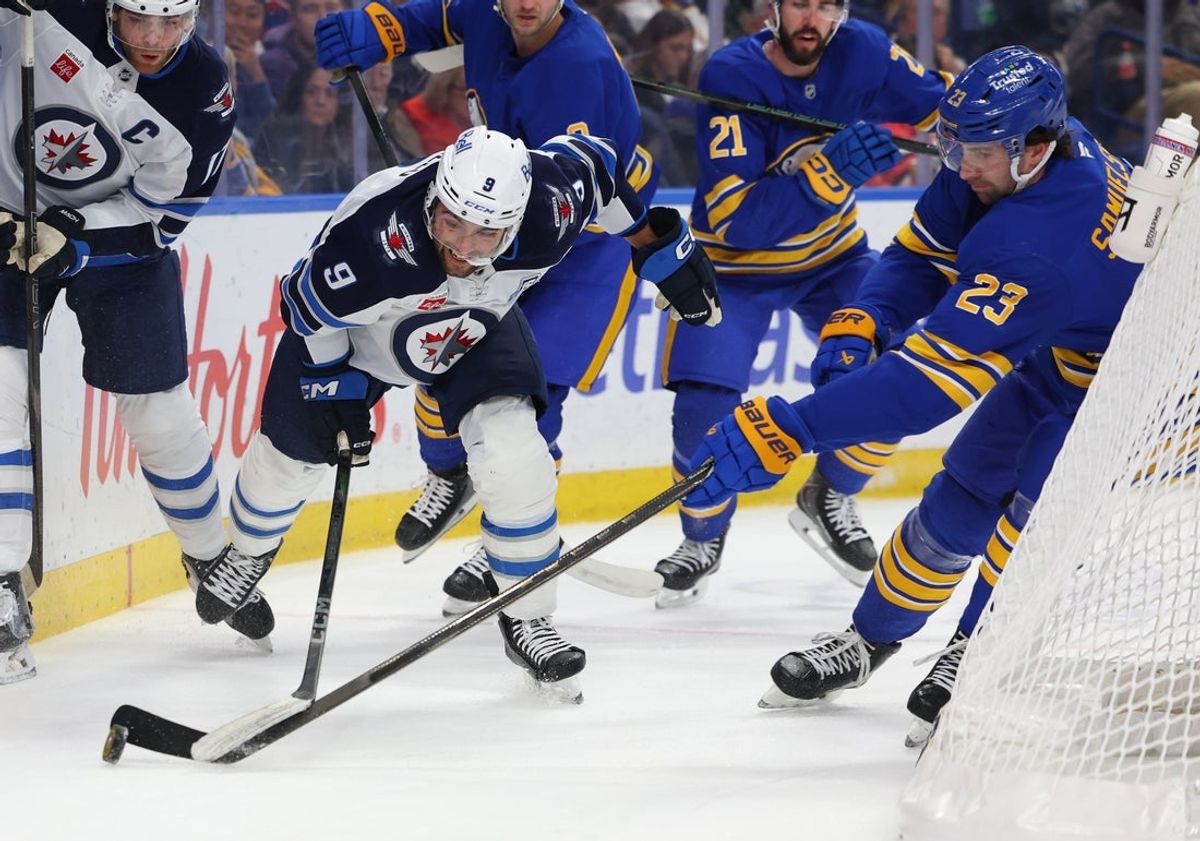 Dec 1, 2025; Buffalo, New York, USA;  Winnipeg Jets left wing Alex Iafallo (9) and Buffalo Sabres defenseman Mattias Samuelsson (23) go after a loose puck behind the net during the first period at KeyBank Center. Mandatory Credit: Timothy T. Ludwig-Imagn Images