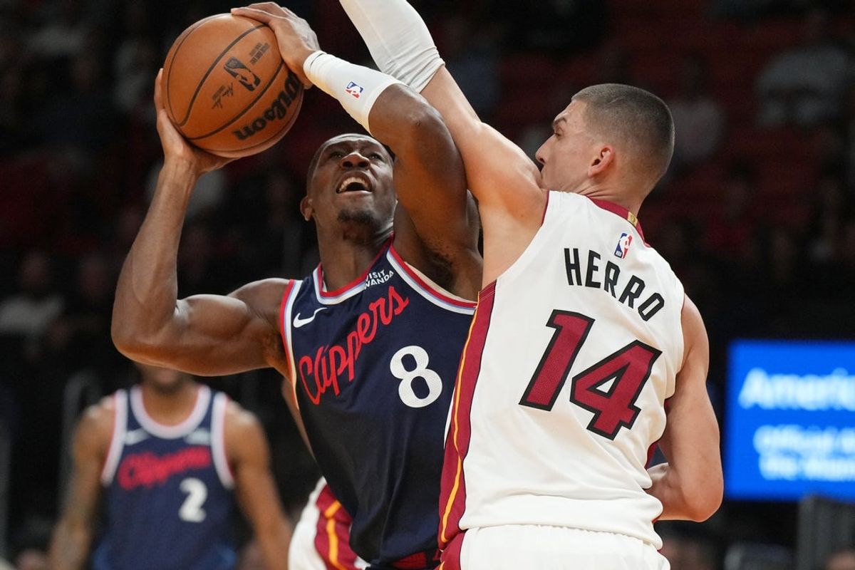 Dec 1, 2025; Miami, Florida, USA; Los Angeles Clippers guard Kris Dunn (8) gets fouled by Miami Heat guard Tyler Herro (14) during the first half at Kaseya Center. Mandatory Credit: Jim Rassol-Imagn Images
