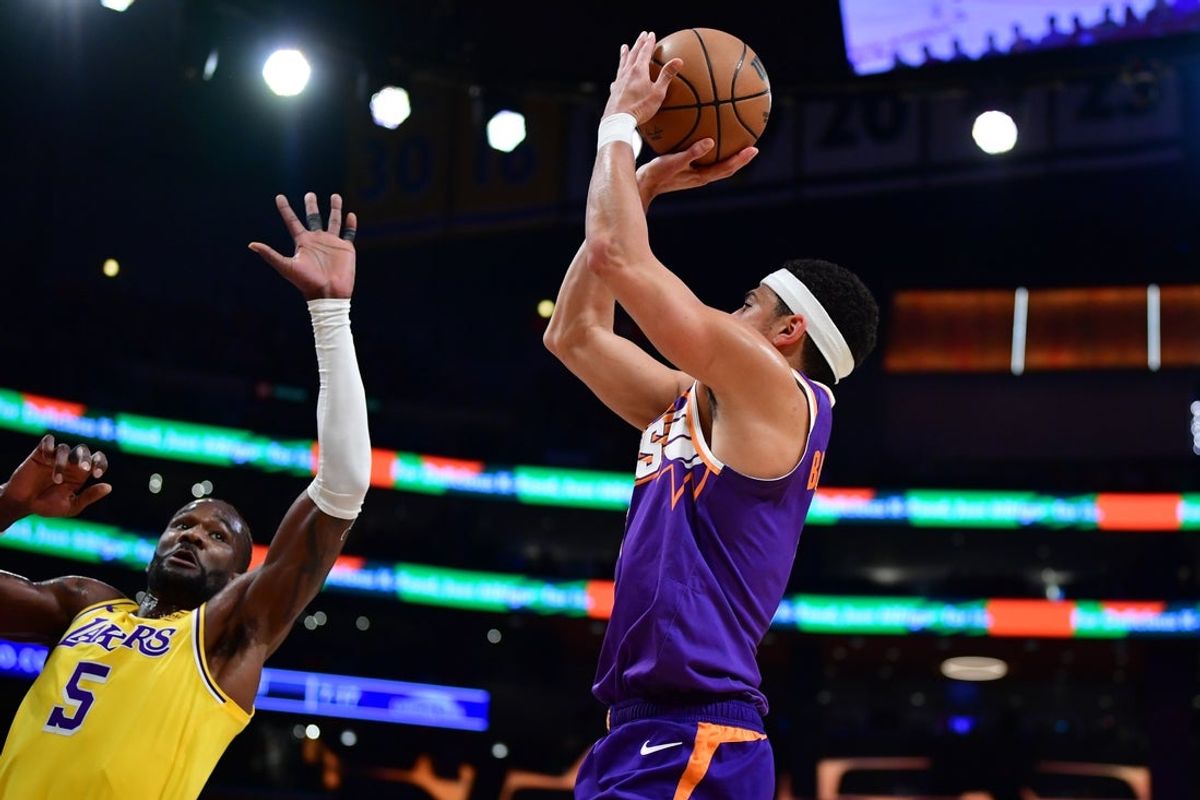 Dec 1, 2025; Los Angeles, California, USA; Phoenix Suns guard Devin Booker (1) shoots against Los Angeles Lakers center Deandre Ayton (5) during the first half at Crypto.com Arena. Mandatory Credit: Gary A. Vasquez-Imagn Images