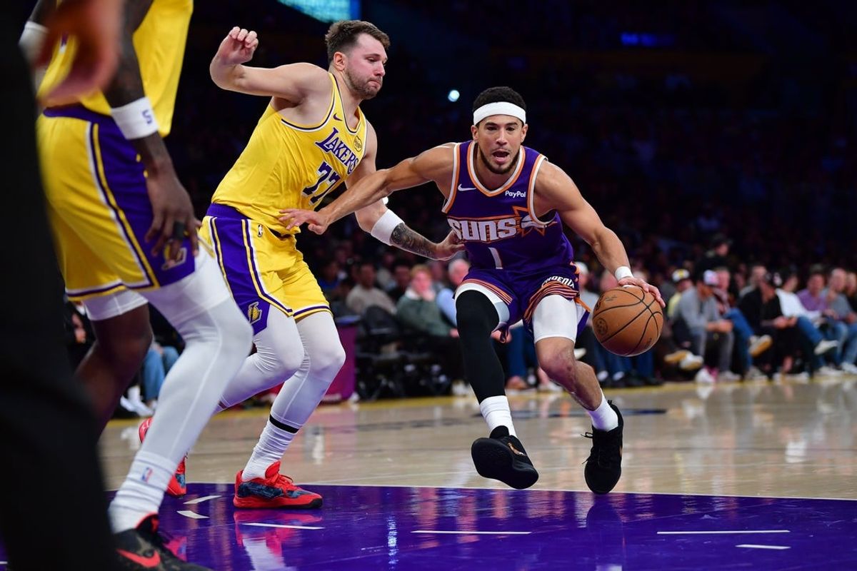 Dec 1, 2025; Los Angeles, California, USA; Phoenix Suns guard Devin Booker (1) moves to the basket against Los Angeles Lakers guard Luka Doncic (77) during the first half at Crypto.com Arena. Mandatory Credit: Gary A. Vasquez-Imagn Images