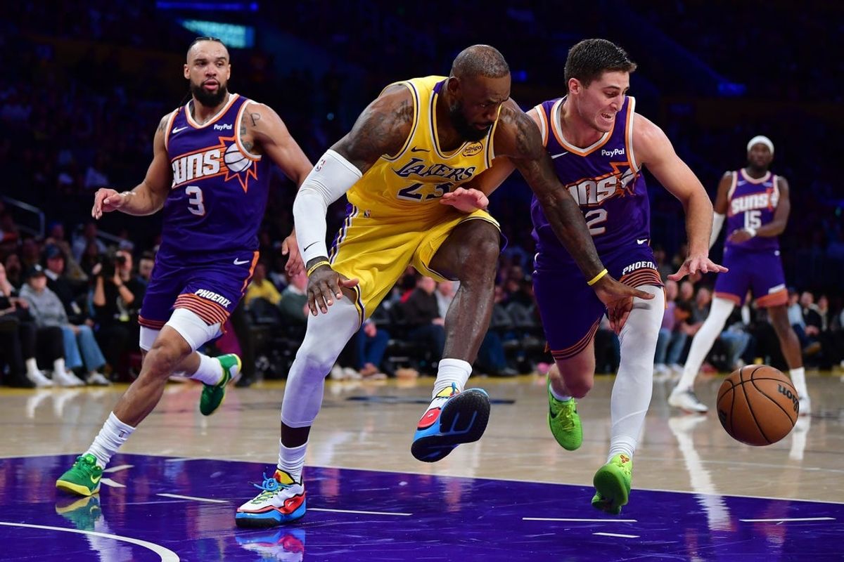 Dec 1, 2025; Los Angeles, California, USA; Los Angeles Lakers forward LeBron James (23) plays for the ball against Phoenix Suns guard Collin Gillespie (12) during the second half at Crypto.com Arena. Mandatory Credit: Gary A. Vasquez-Imagn Images