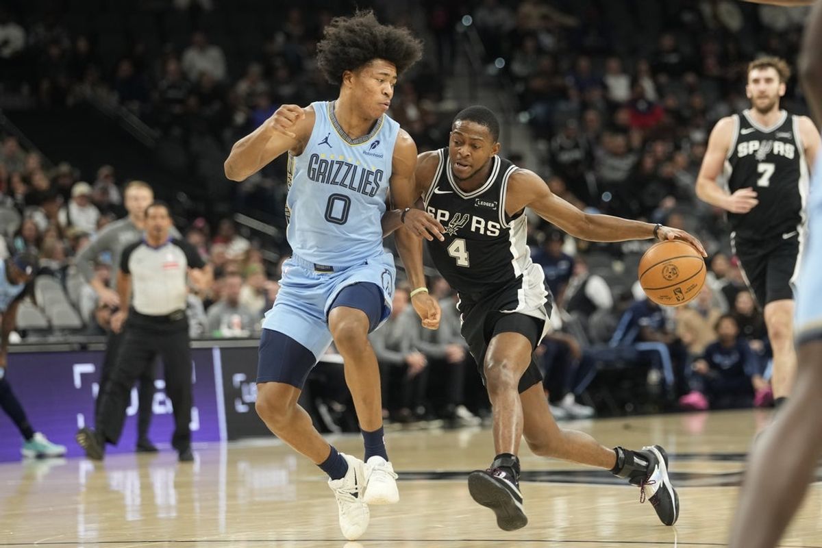 Dec 2, 2025; San Antonio, Texas, USA; San Antonio Spurs guard De’Aaron Fox (4) drives to the basket against Memphis Grizzlies guard Jaylen Wells (0) during the first half at Frost Bank Center. Mandatory Credit: Scott Wachter-Imagn Images