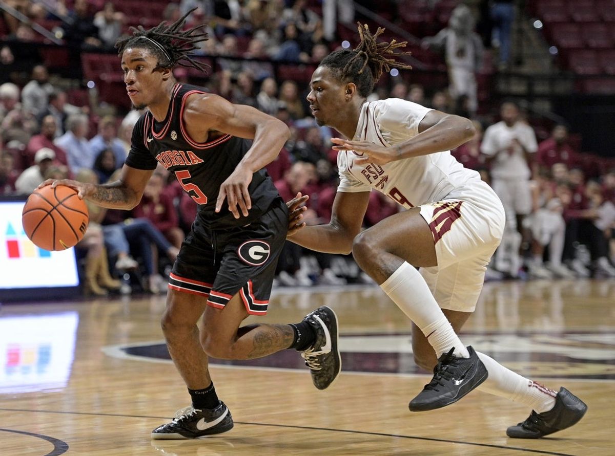 Dec 2, 2025; Tallahassee, Florida, USA; Georgia Bulldogs guard Jeremiah Wilkinson (5) drives the ball around Florida State Seminoles forward AJ Swinton (19) during the second half at Donald L. Tucker Center. Mandatory Credit: Melina Myers-Imagn Images