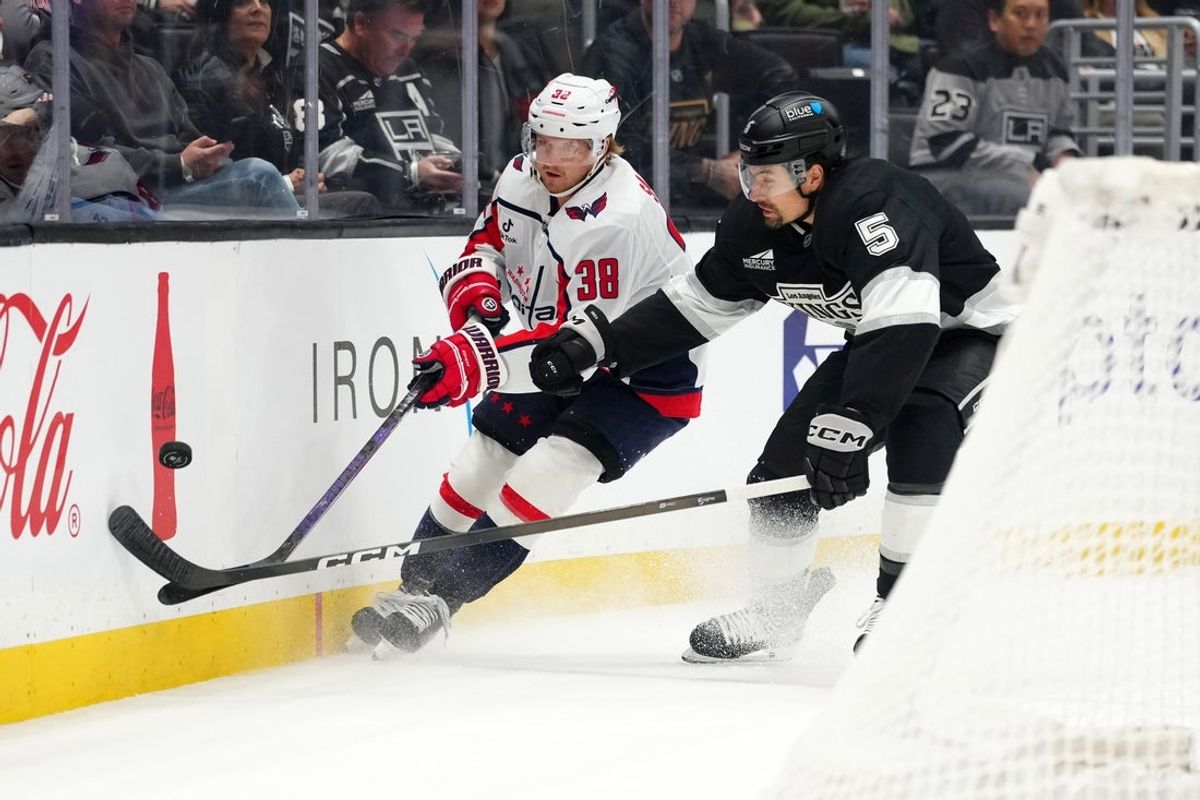 Dec 2, 2025; Los Angeles, California, USA; Washington Capitals defenseman Rasmus Sandin (38) and LA Kings defenseman Cody Ceci (5) battle for the puck in the first period at Crypto.com Arena. Mandatory Credit: Kirby Lee-Imagn Images