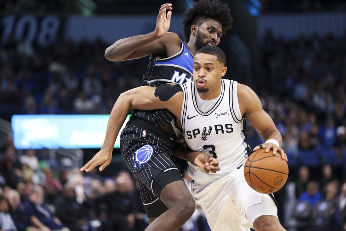 Dec 3, 2025; Orlando, Florida, USA; San Antonio Spurs forward Keldon Johnson (3) moves the ball past Orlando Magic forward Jonathan Isaac (1) in the second quarter at Kia Center. Mandatory Credit: Nathan Ray Seebeck-Imagn Images