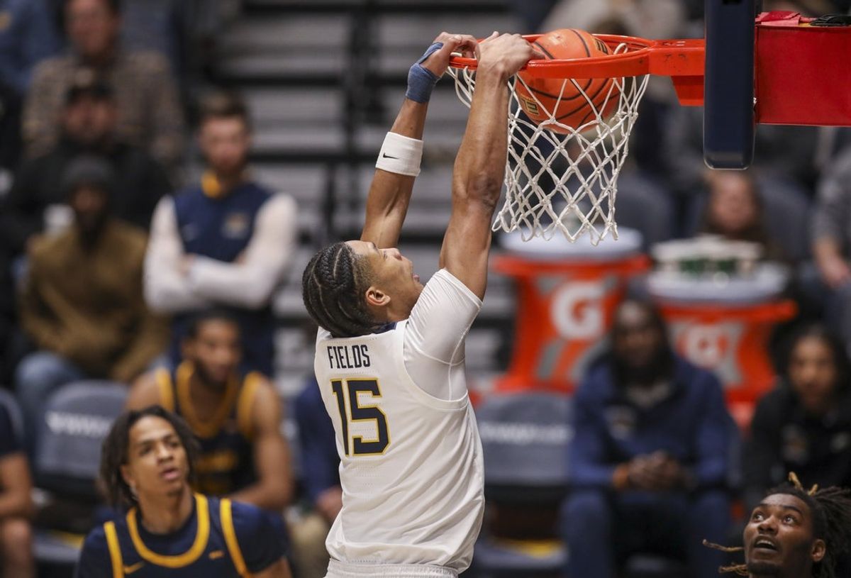 Dec 3, 2025; Morgantown, West Virginia, USA; West Virginia Mountaineers forward Jackson Fields (15) dunks during the first half against the Coppin State Eagles at Hope Coliseum. Mandatory Credit: Ben Queen-Imagn Images