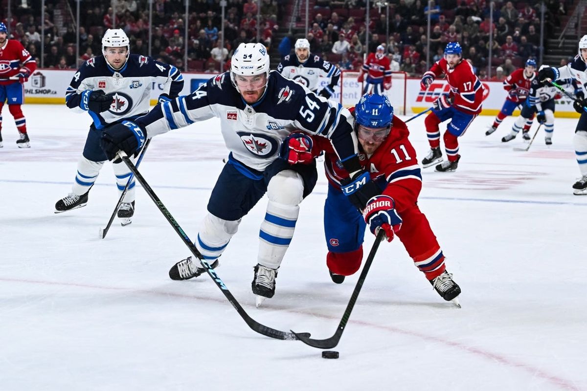Dec 3, 2025; Montreal, Quebec, CAN; Winnipeg Jets defenseman Dylan Samberg (54) defends the puck against Montreal Canadiens right wing Brendan Gallagher (11) during the first period at Bell Centre. Mandatory Credit: David Kirouac-Imagn Images