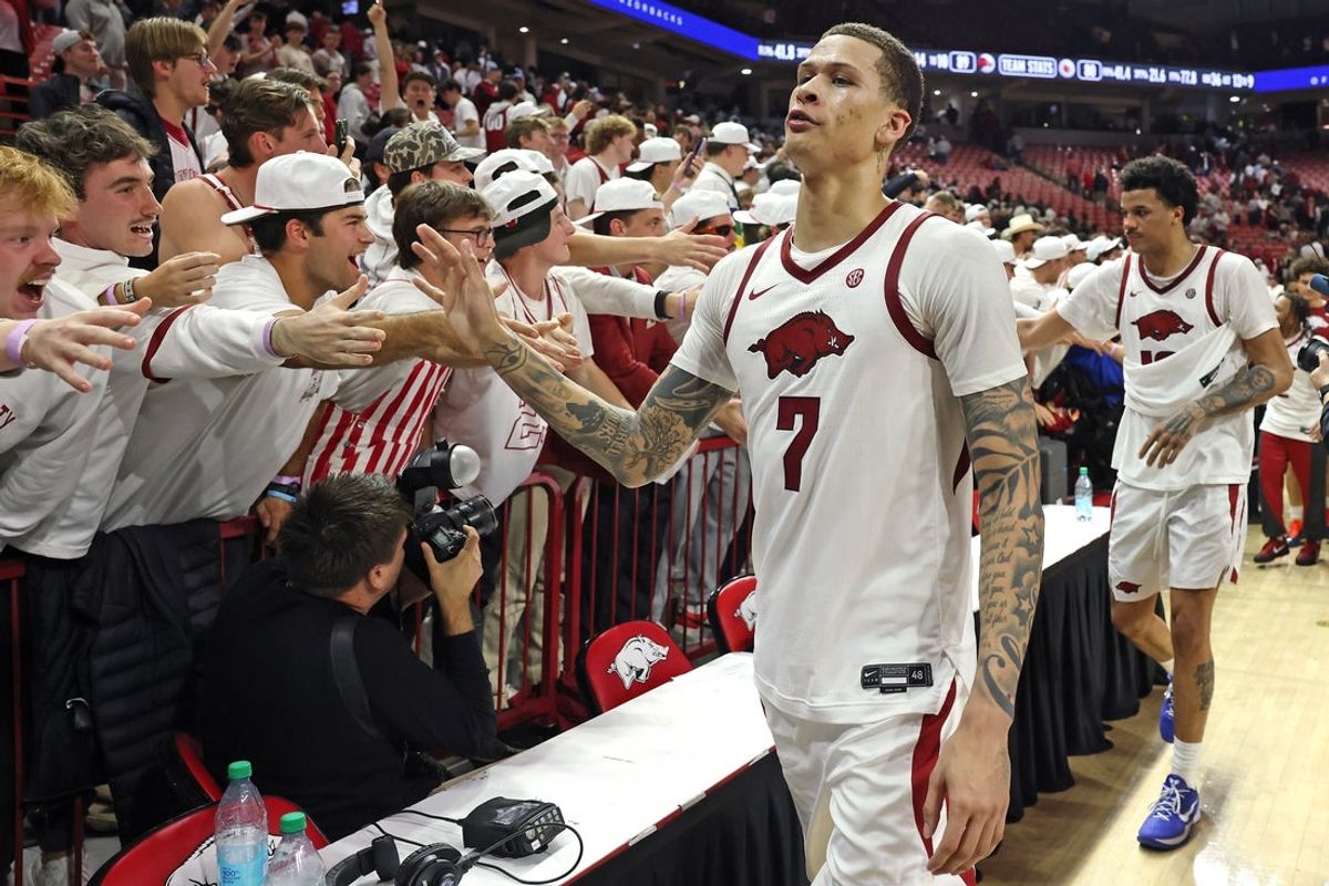 Dec 3, 2025; Fayetteville, Arkansas, USA; Arkansas Razorbacks forward Trevon Brazile (7) celebrates with fans after a game against the Louisville Cardinals at Bud Walton Arena. Arkansas won 89-80. Mandatory Credit: Nelson Chenault-Imagn Images