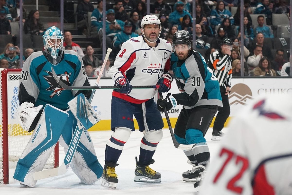 Dec 3, 2025; San Jose, California, USA;  San Jose Sharks goaltender Yaroslav Askarov (30) defends the goal as Washington Capitals left winger Alex Ovechkin (8) and San Jose Sharks defenseman Mario Ferraro (38) wait for the puck in the first period at SAP Center at San Jose. Mandatory Credit: David Gonzales-Imagn Images