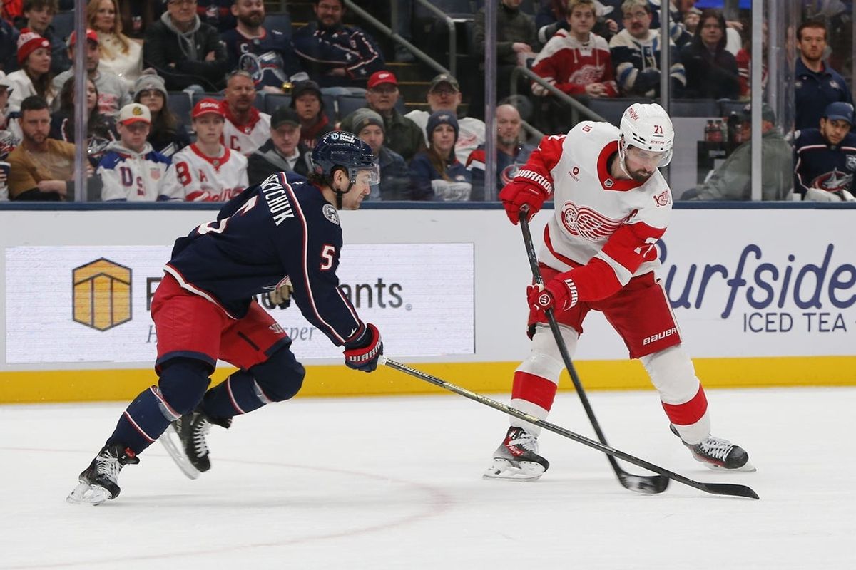 Dec 4, 2025; Columbus, Ohio, USA; Detroit Red Wings center Dylan Larkin (71) wrists a shot on goal as Columbus Blue Jackets defenseman Denton Mateychuk (5) defends during the first period at Nationwide Arena. Mandatory Credit: Russell LaBounty-Imagn Images