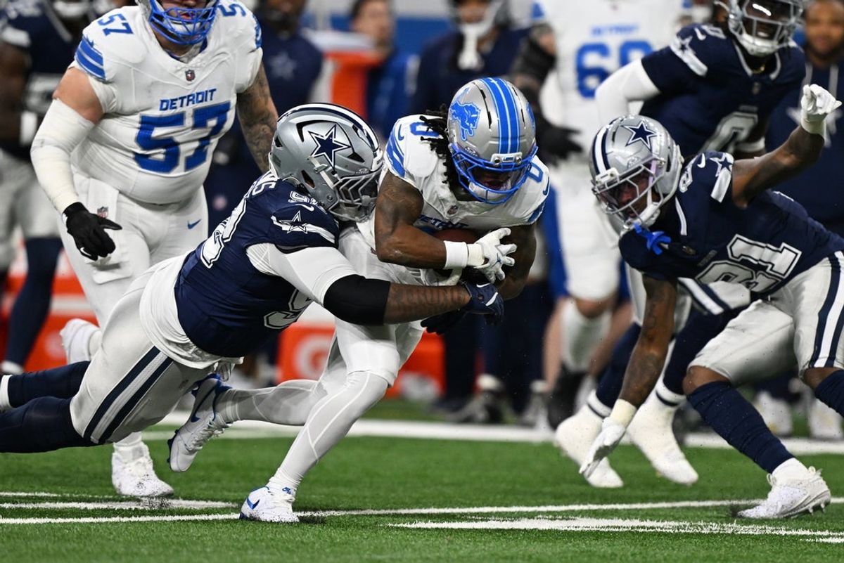 Dec 4, 2025; Detroit, Michigan, USA; Detroit Lions running back Jahmyr Gibbs (0) is tackled by Dallas Cowboys defensive tackle Quinnen Williams (92) during the first half at Ford Field. Mandatory Credit: Lon Horwedel-Imagn Images
