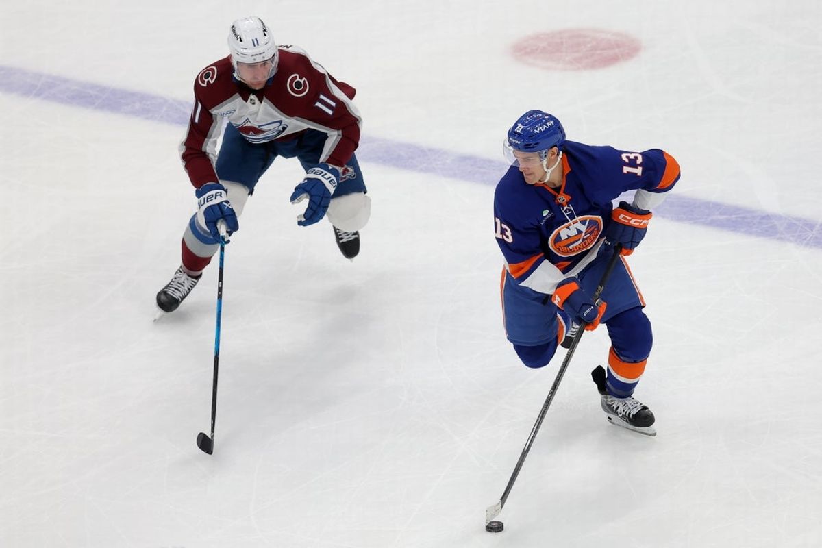 Dec 4, 2025; Elmont, New York, USA; New York Islanders center Mathew Barzal (13) skates with the puck against Colorado Avalanche center Brock Nelson (11) during the second period at UBS Arena. Mandatory Credit: Brad Penner-Imagn Images