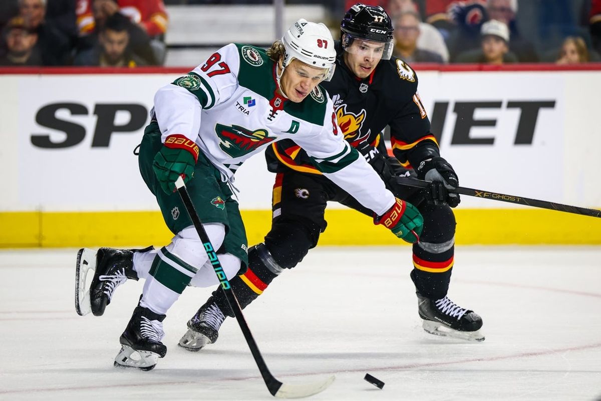 Dec 4, 2025; Calgary, Alberta, CAN; Minnesota Wild left wing Kirill Kaprizov (97) and Calgary Flames center Yegor Sharangovich (17) battle for the puck during the second period at Scotiabank Saddledome. Mandatory Credit: Sergei Belski-Imagn Images