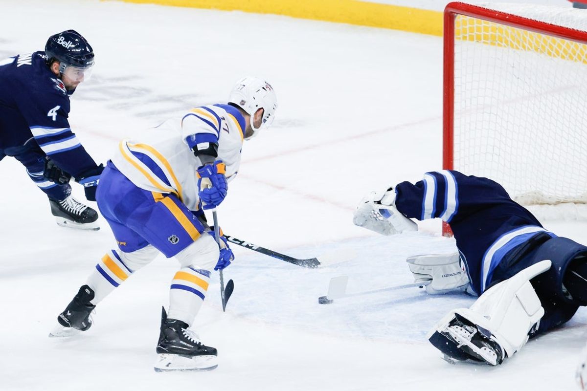 Dec 5, 2025; Winnipeg, Manitoba, CAN;  Buffalo Sabres forward Jason Zucker (17) scores on Winnipeg Jets goalie Eric Comrie (1) during the first period at Canada Life Centre. Mandatory Credit: Terrence Lee-Imagn Images