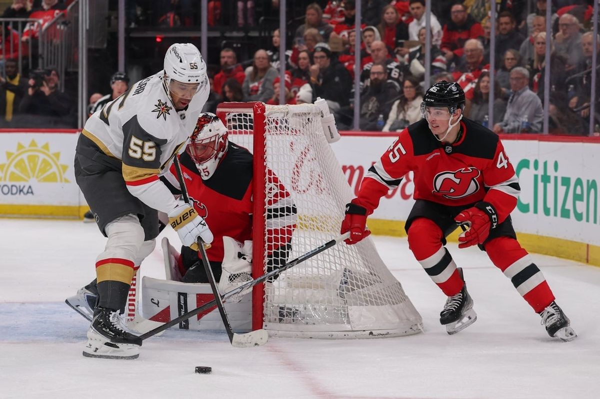 Dec 5, 2025; Newark, New Jersey, USA; Vegas Golden Knights right wing Keegan Kolesar (55) plays the puck as New Jersey Devils defenseman Colton White (45) defends during the first period at Prudential Center. Mandatory Credit: Ed Mulholland-Imagn Images