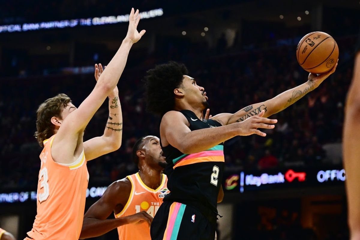 Dec 5, 2025; Cleveland, Ohio, USA; San Antonio Spurs guard Dylan Harper (2) drives to the basket against Cleveland Cavaliers forward Luke Travers (33) during the first half at Rocket Arena. Mandatory Credit: Ken Blaze-Imagn Images