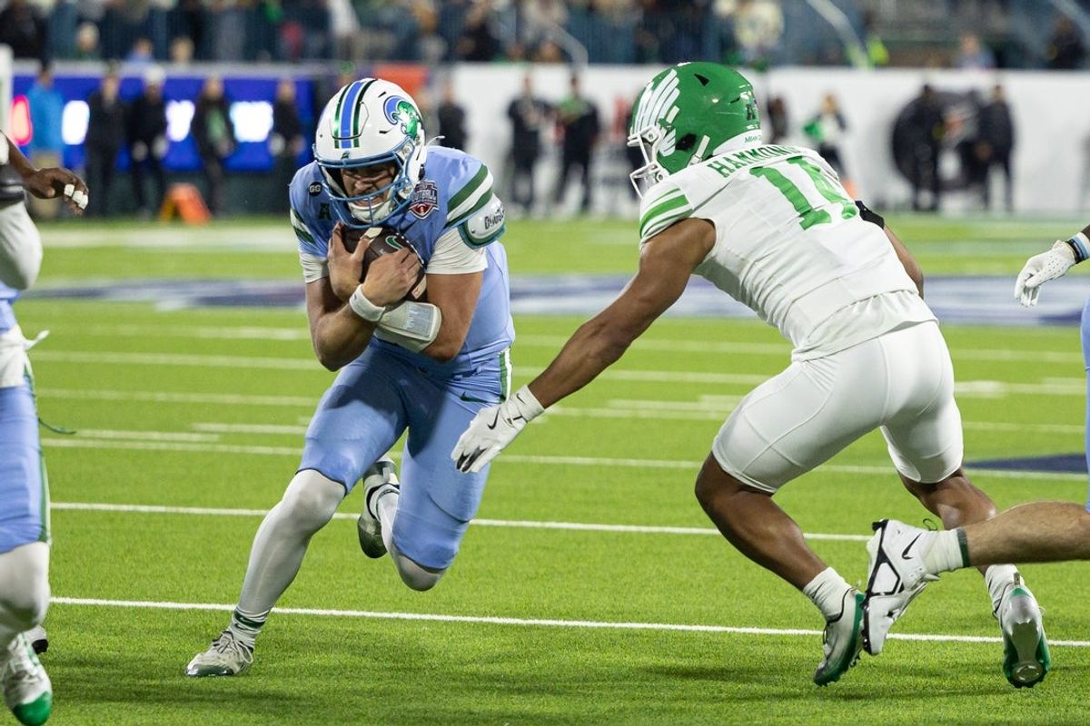 Dec 5, 2025; New Orleans, LA, USA;  Tulane Green Wave quarterback Jake Retzlaff (12)  rushes against North Texas Mean Green safety Quinton Hammonds (14) during the first half in the 2025 American Championship at Yulman Stadium. Mandatory Credit: Stephen Lew-Imagn Images