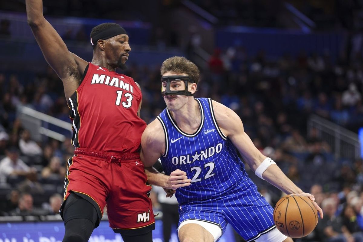Dec 5, 2025; Orlando, Florida, USA; Orlando Magic forward Franz Wagner (22) drives to the basket past Miami Heat center Bam Adebayo (13) in the third quarter at Kia Center. Mandatory Credit: Nathan Ray Seebeck-Imagn Images