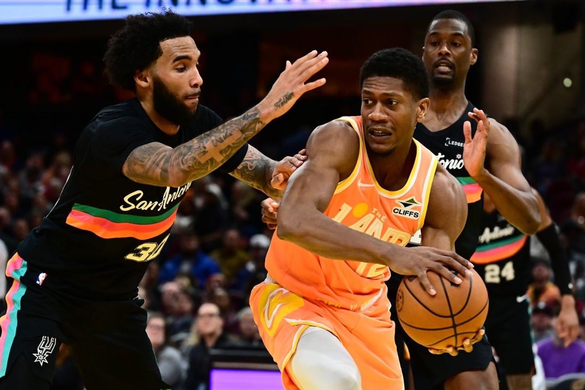 Dec 5, 2025; Cleveland, Ohio, USA; Cleveland Cavaliers forward De'Andre Hunter (12) looks to pass against San Antonio Spurs forward Julian Champagnie (30) during the second half at Rocket Arena. Mandatory Credit: Ken Blaze-Imagn Images