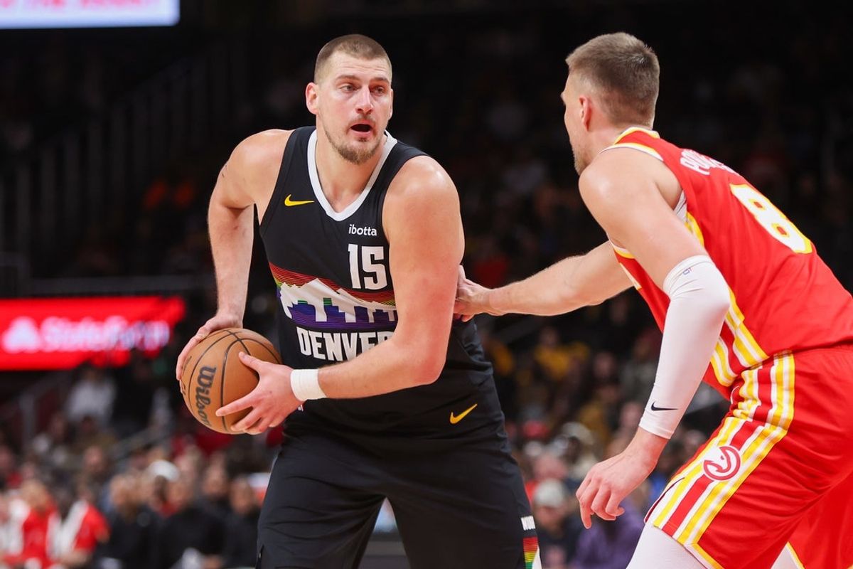 Dec 5, 2025; Atlanta, Georgia, USA; Denver Nuggets center Nikola Jokic (15) is defended by Atlanta Hawks center Kristaps Porzingis (8) in the fourth quarter at State Farm Arena. Mandatory Credit: Brett Davis-Imagn Images