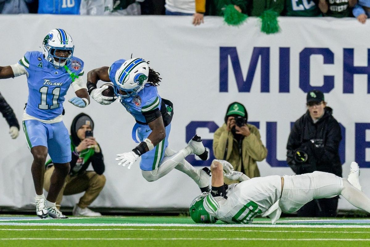 Dec 5, 2025; New Orleans, LA, USA;  Tulane Green Wave safety Jack Tchienchou (1) intercepts a tipped pass intended for North Texas Mean Green wide receiver Wyatt Young (10) during the second half in the 2025 American Championship at Yulman Stadium. Mandatory Credit: Stephen Lew-Imagn Images