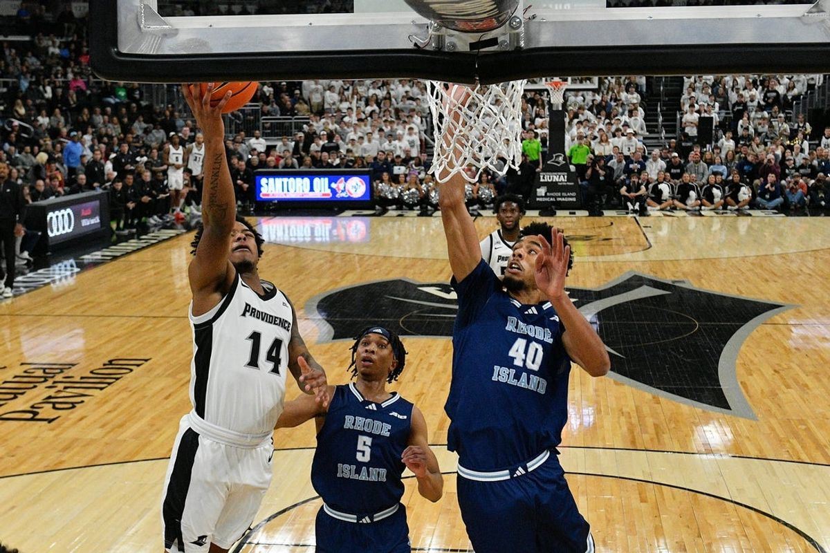 Dec 6, 2025; Providence, Rhode Island, USA; Providence Friars guard Jr. Corey Floyd (14) shoots a layup against Rhode Island Rams forward Keeyan Itejere (40) during the first half at Amica Mutual Pavilion. Mandatory Credit: Eric Canha-Imagn Images
