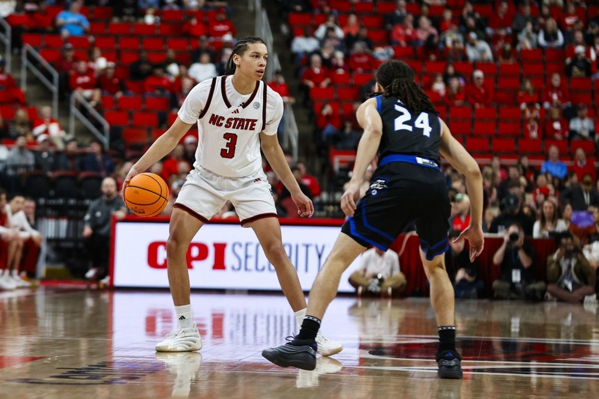 Dec 6, 2025; Raleigh, North Carolina, USA; NC State Wolfpack guard Matt Able (3) dribbles the ball against UNC Asheville Bulldogs guard Corey Jones (24) during the first half of the game at Lenovo Center. Mandatory Credit: Jaylynn Nash-Imagn Images