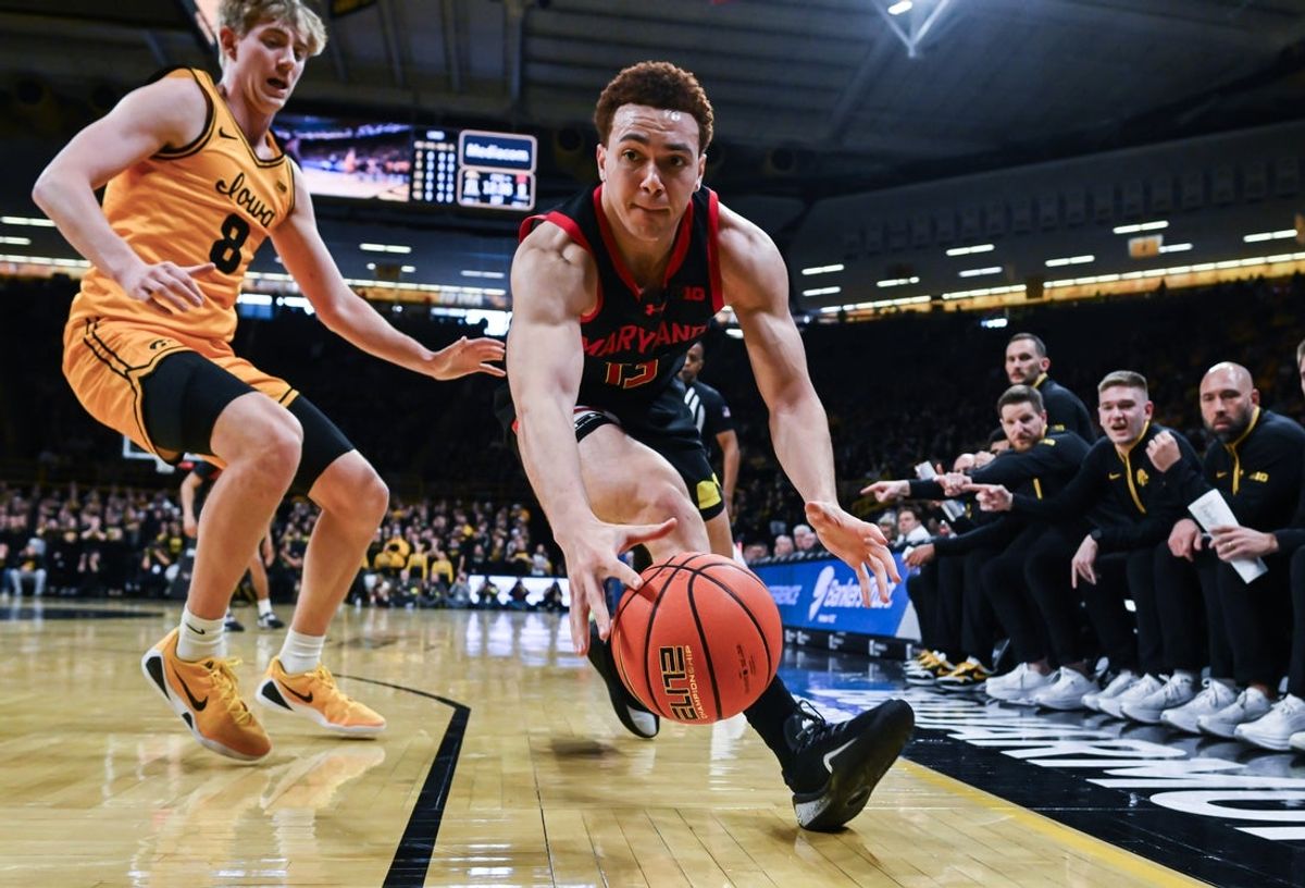 Dec 6, 2025; Iowa City, Iowa, USA; Maryland Terrapins forward Elijah Saunders (13) gathers a loose ball as Iowa Hawkeyes forward Cooper Koch (8) defends during the first half at Carver-Hawkeye Arena. Mandatory Credit: Jeffrey Becker-Imagn Images