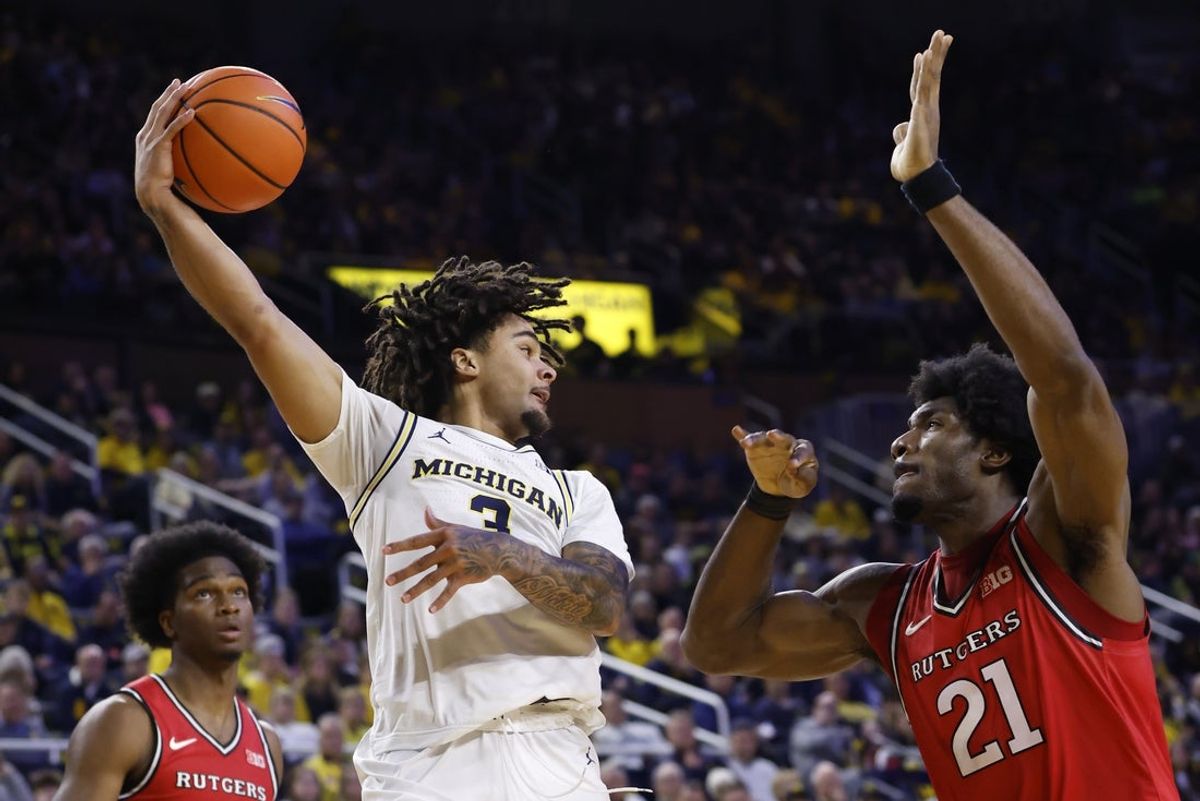 Dec 6, 2025; Ann Arbor, Michigan, USA;  Michigan Wolverines guard Elliot Cadeau (3) passes over Rutgers Scarlet Knights center Emmanuel Ogbole (21) in the first half at Crisler Center. Mandatory Credit: Rick Osentoski-Imagn Images