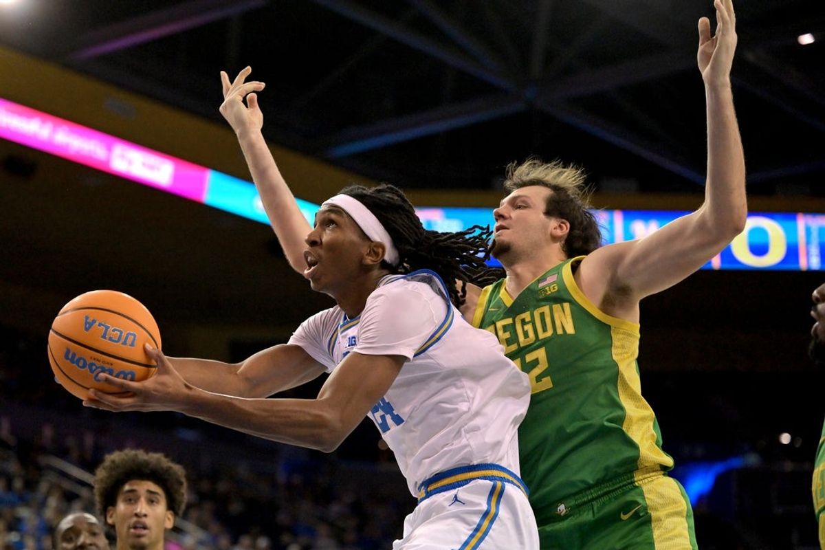 Dec 6, 2025; Los Angeles, California, USA;  UCLA Bruins forward Steven Jamerson II (24) drives past Oregon Ducks center Nate Bittle (32) for a basket during the first half at Pauley Pavilion presented by Wescom Financial. Mandatory Credit: Jayne Kamin-Oncea-Imagn Images