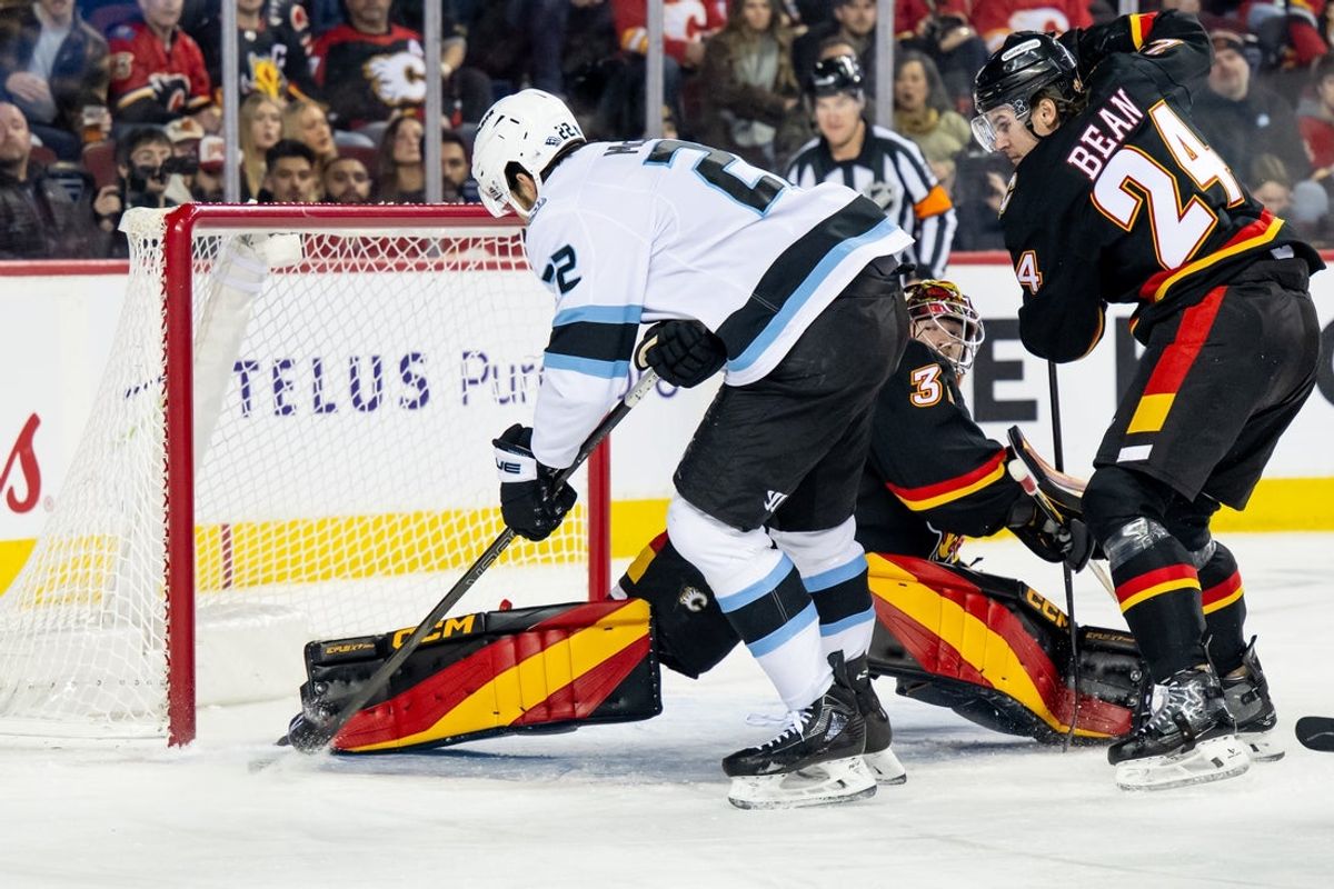 Dec 6, 2025; Calgary, Alberta, CAN; Calgary Flames goaltender Dustin Wolf (32) makes a save on Utah Mammoth center Jack McBain (22) during the first period at Scotiabank Saddledome. Mandatory Credit: Brett Holmes-Imagn Images