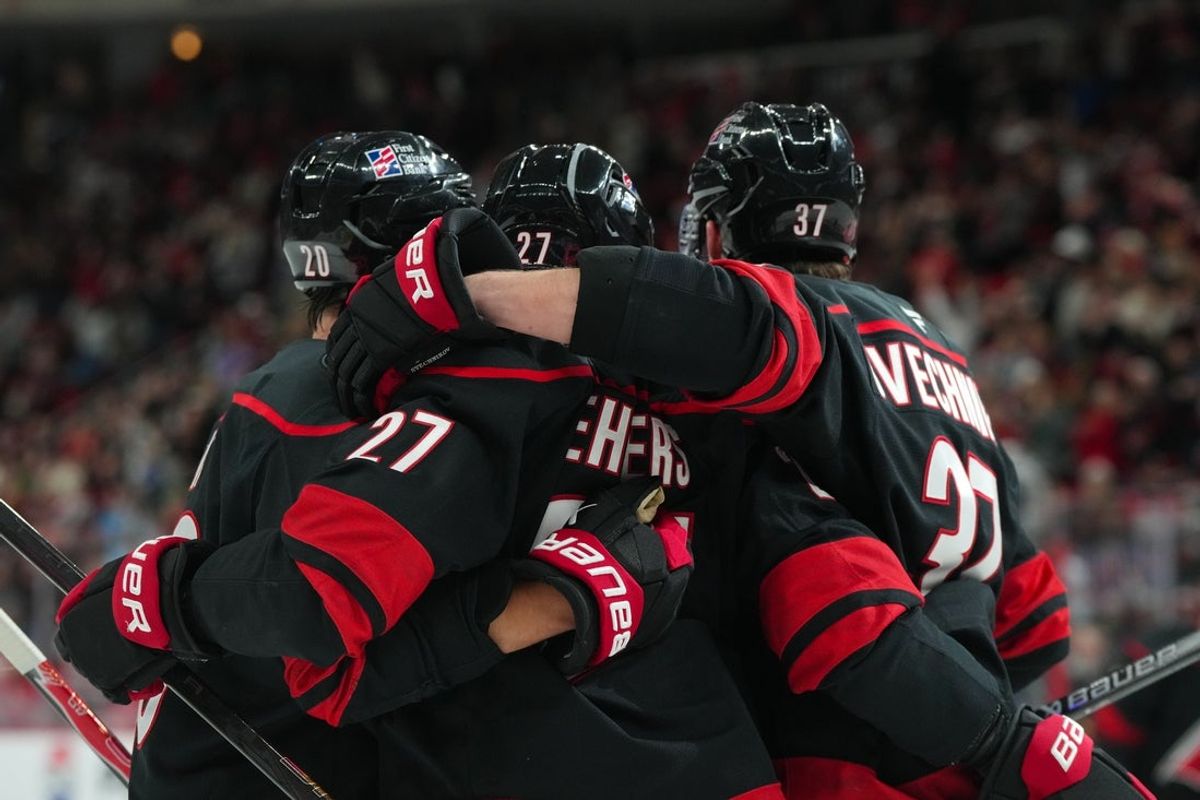 Dec 6, 2025; Raleigh, North Carolina, USA;  Carolina Hurricanes left wing Nikolaj Ehlers (27) celebrates his goal with center Sebastian Aho (20) and right wing Andrei Svechnikov (37) during the first period at Lenovo Center. Mandatory Credit: James Guillory-Imagn Images