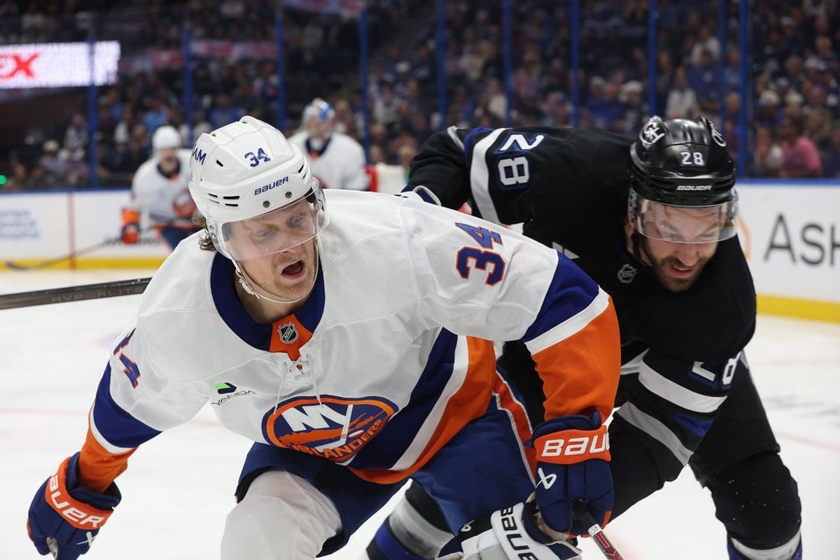 Dec 6, 2025; Tampa, Florida, USA; New York Islanders defenseman Adam Boqvist (34) skates for the puck as Tampa Bay Lightning center Zemgus Girgensons (28) defends during the third period at Benchmark International Arena. Mandatory Credit: Kim Klement Neitzel-Imagn Images
