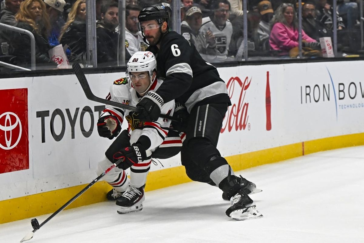 Dec 6, 2025; Los Angeles, California, USA; Chicago Blackhawks center Ryan Greene (20) skates with the puck against Los Angeles Kings defenseman Joel Edmundson (6) during the first period at Crypto.com Arena. Mandatory Credit: Jonathan Hui-Imagn Images