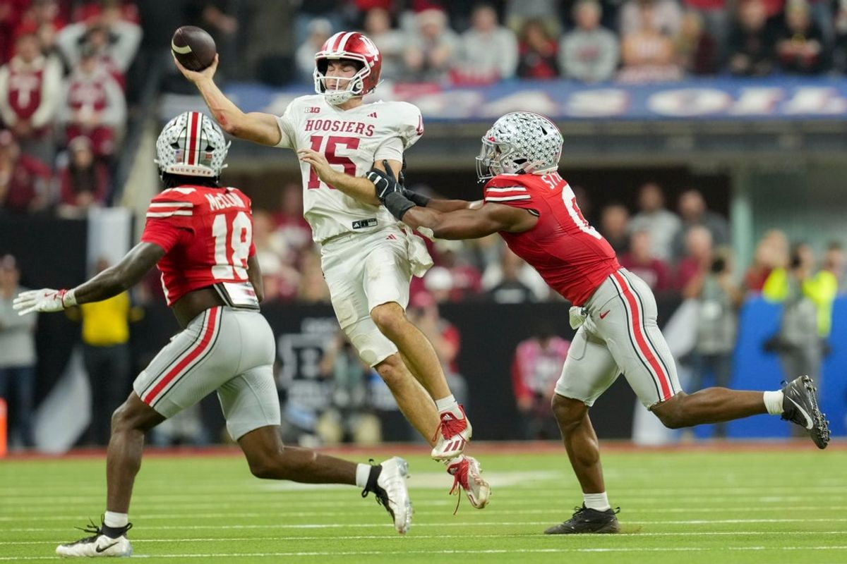 Indiana Hoosiers quarterback Fernando Mendoza (15) looks to throw as Ohio State Buckeyes safety Jaylen McClain (18) and Ohio State Buckeyes linebacker Sonny Styles (0) move in Saturday, Dec. 6, 2025, during the Big Ten football championship at Lucas Oil Stadium in Indianapolis.