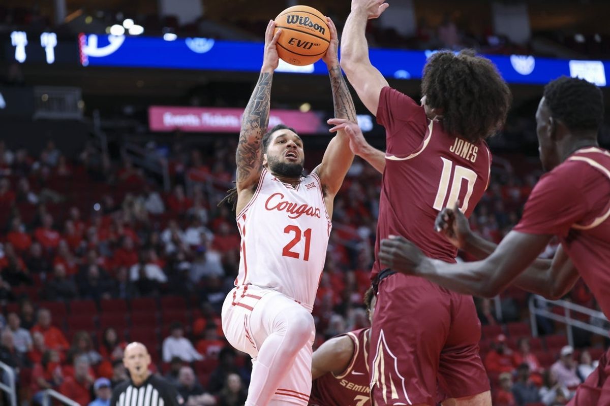 Dec 6, 2025; Houston, TX, USA; Houston Cougars guard Emanuel Sharp (21) drives to the basket as Florida State Seminoles guard Lajae Jones (10) defends during the first half at Toyota Center. Mandatory Credit: Troy Taormina-Imagn Images