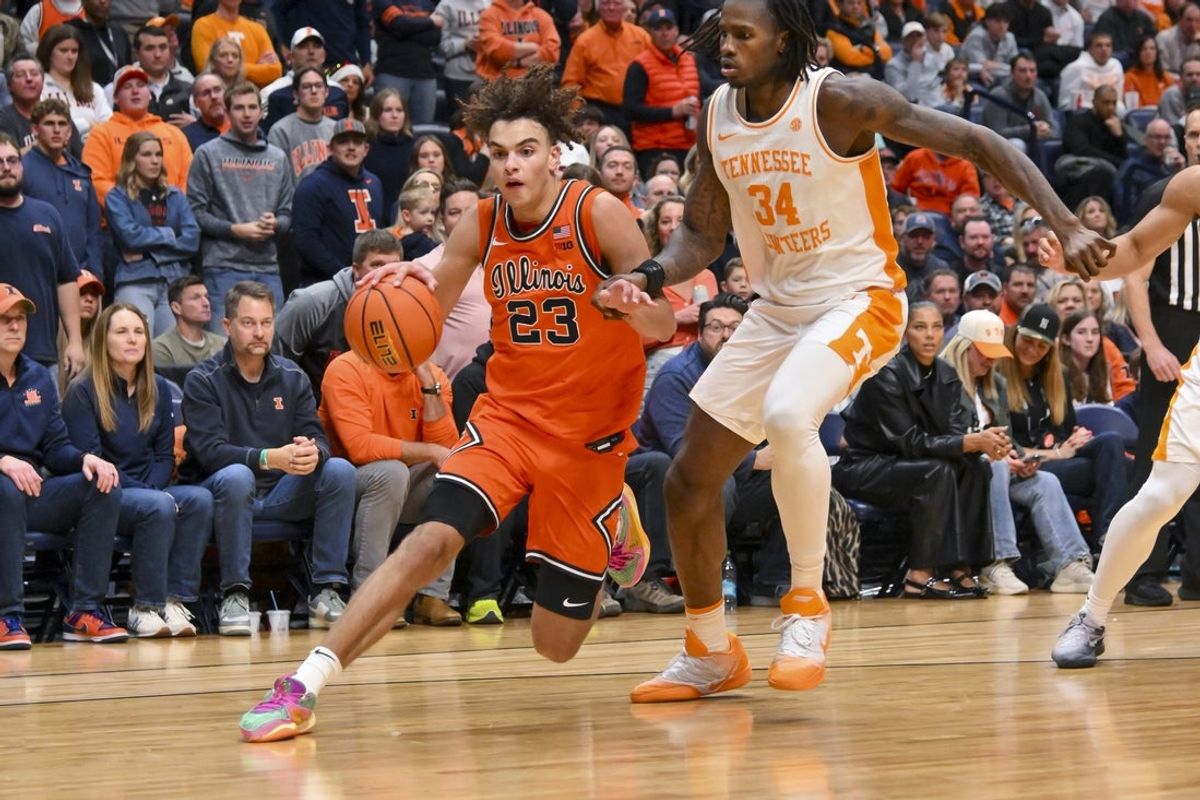 Dec 6, 2025; Nashville, Tennessee, USA;  Illinois Fighting Illini guard Keaton Wagler (23) drives to the baseline past Tennessee Volunteers center Felix Okpara (34) during the second half at Bridgestone Arena. Mandatory Credit: Steve Roberts-Imagn Images