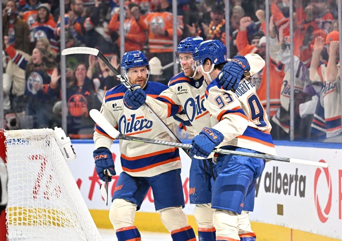 Dec 6, 2025; Edmonton, Alberta, CAN; Edmonton Oilers Brett Kulak (27) with Oiloers center Connor McDavid (97) and Oilers center Ryan Nugent-Hopkins (93) celebrates a goal on Winnipeg Jets goalie Eric Comrie (1) during the first period at Rogers Place. Mandatory Credit: Walter Tychnowicz-Imagn Images