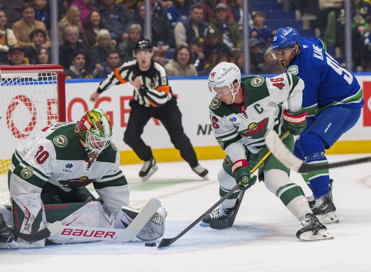 Dec 6, 2025; Vancouver, British Columbia, CAN;  Minnesota Wild goalie Jesper Wallstedt (30) (L), Minnesota Wild defenceman Jared Spurgeon (46)  and Vancouver Canucks left wing Evander Kane (91) scramble for the puck in front of the net at Rogers Arena. Mandatory Credit: Christopher Morris-Imagn Images