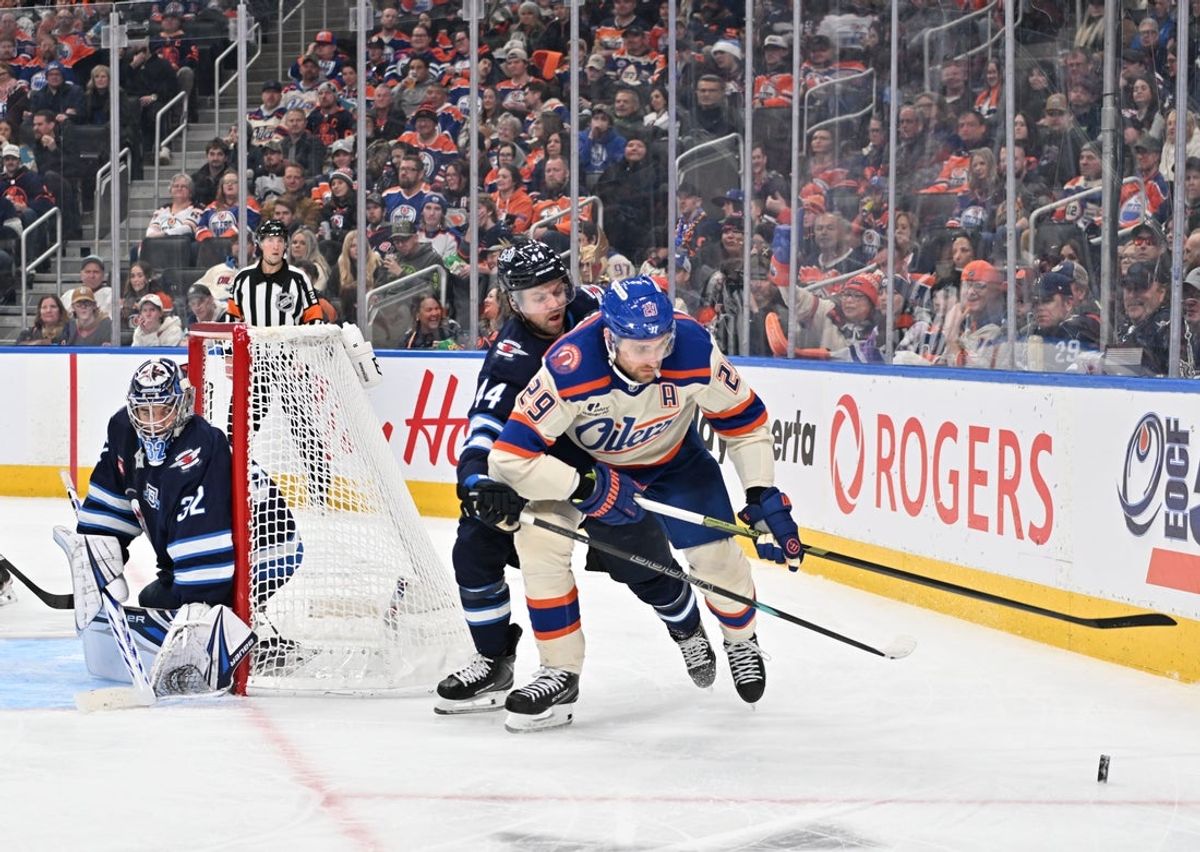 Dec 6, 2025; Edmonton, Alberta, CAN; Winnipeg Jets goalie Thomas Milic (32) watches Edmonton Oilers center Leon Draisaitl (29) chase the puck with Winnipeg Jets defenseman Josh Morrissey (44) during the third period at Rogers Place. Mandatory Credit: Walter Tychnowicz-Imagn Images