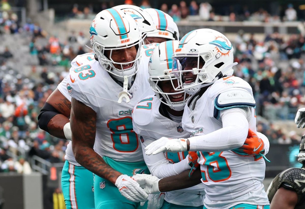 Dec 7, 2025; East Rutherford, New Jersey, USA; Miami Dolphins running back De'Von Achane (28) celebrates with tight end Darren Waller (83) and wide receiver Jaylen Waddle (17) after scoring a touchdown against the New York Jets during the first half at MetLife Stadium. Mandatory Credit: Ed Mulholland-Imagn Images