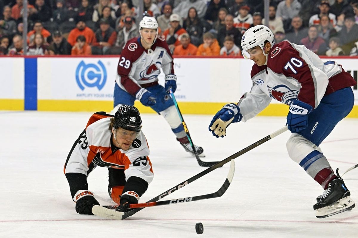 Dec 7, 2025; Philadelphia, Pennsylvania, USA; Philadelphia Flyers right wing Nikita Grebenkin (29) dives for the puck against Colorado Avalanche defenseman Sam Malinski (70) during the first period at Xfinity Mobile Arena. Mandatory Credit: Eric Hartline-Imagn Images
