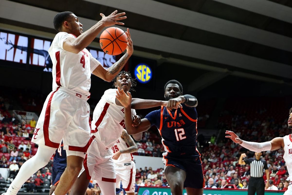 Dec 7, 2025; Tuscaloosa, Alabama, USA; Alabama Crimson Tide guard Davion Hannah (4) grabs a rebound against UTSA Roadrunners forward Daniel Akitoby (12) during the first half at Coleman Coliseum. Mandatory Credit: David Leong-Imagn Images