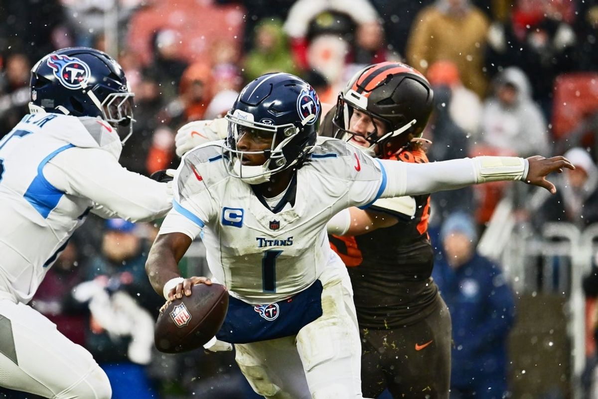 Dec 7, 2025; Cleveland, Ohio, USA; Tennessee Titans quarterback Cam Ward (1) runs with the ball against Cleveland Browns linebacker Carson Schwesinger (49) during the third quarter at Huntington Bank Field. Mandatory Credit: Ken Blaze-Imagn Images