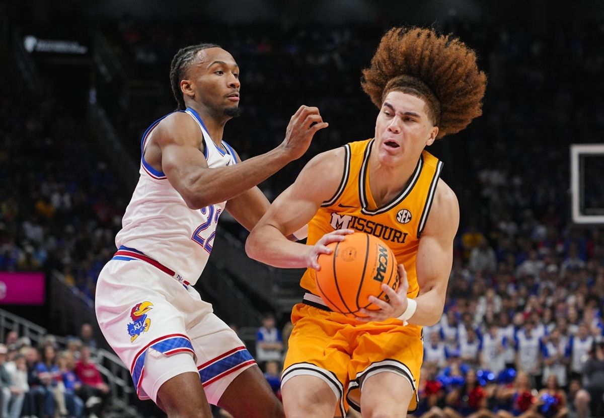 Dec 7, 2025; Kansas City, Missouri, USA; Missouri Tigers guard T.O. Barrett (5) drives against Kansas Jayhawks guard Darryn Peterson (22) during the second half at T-Mobile Center. Mandatory Credit: Jay Biggerstaff-Imagn Images