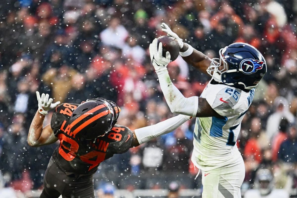Dec 7, 2025; Cleveland, Ohio, USA; Tennessee Titans safety Xavier Woods (25) intercepts a pass intended for Cleveland Browns wide receiver Gage Larvadain (84) during the third quarter at Huntington Bank Field. Mandatory Credit: Ken Blaze-Imagn Images