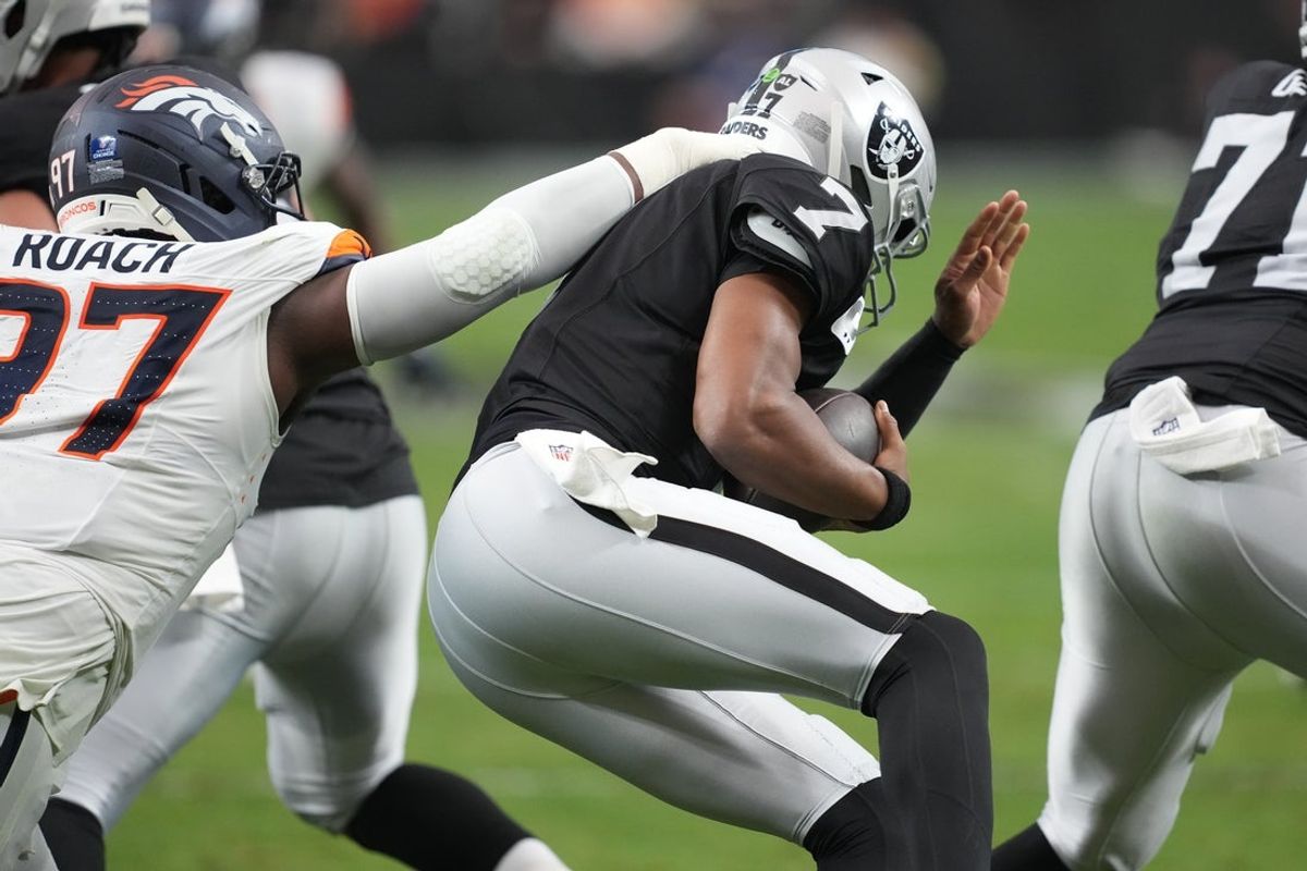 Dec 7, 2025; Paradise, Nevada, USA;  Las Vegas Raiders quarterback Geno Smith (7) is sacked by Denver Broncos defensive tackle Malcolm Roach (97) during the first half at Allegiant Stadium. Mandatory Credit: Kirby Lee-Imagn Images